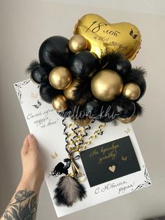 the balloon bouquet is filled with black and gold balloons