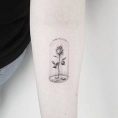 a rose in a glass jar tattoo on the arm