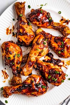 a white plate topped with chicken wings and garnished with cilantro