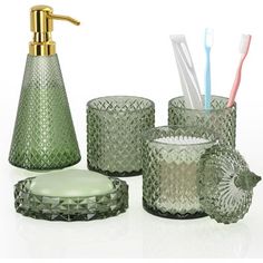 an assortment of green glass items including toothbrushes and soap dispenser