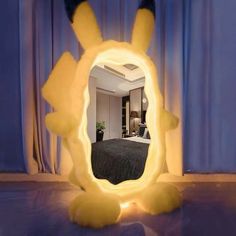 a mirror that is sitting on the floor in front of a bed with a pokemon figure