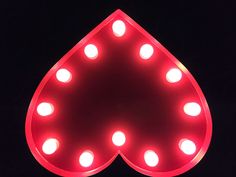 a red neon sign with lights on it's sides in the shape of a tear