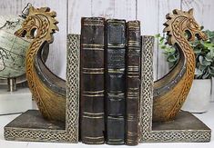 two books are sitting on top of each other in front of a white wooden wall