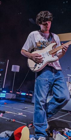 a young man playing an electric guitar on stage