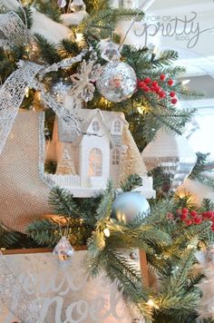 the christmas tree is decorated with silver and white ornaments, including an ornament