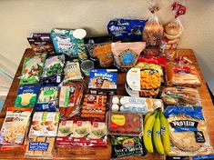 a wooden table topped with lots of food and snacks on top of eachother