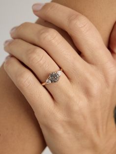 a woman's hand with a diamond ring on it