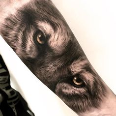 a man's arm with a wolf tattoo on it