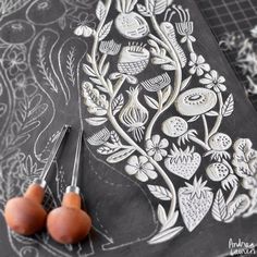 two oranges sitting on top of a cutting board next to some scissors and thread