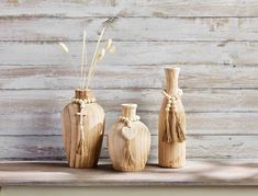 three wooden vases sitting on top of a shelf