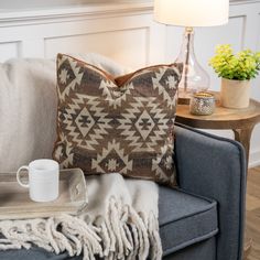 a blue couch with a white coffee cup on top of it and a throw pillow