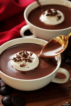 two white bowls filled with chocolate pudding and topped with whipped cream