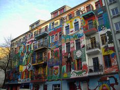 a multi - colored building with lots of windows and balconies on the side