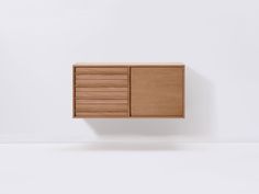 a wooden cabinet sitting on top of a white wall