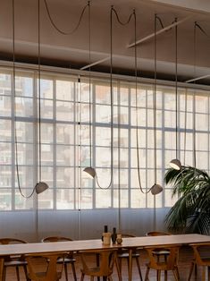 a long table and chairs in front of large windows