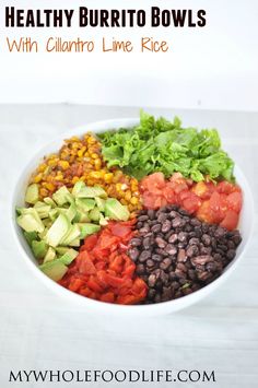 a bowl filled with beans, avocado, tomatoes and lettuce