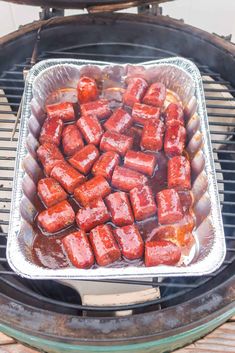 hot dogs cooking on an outdoor grill with ketchup