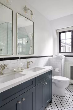 a bathroom with black and white tile flooring and two mirrors on the wall above the sinks