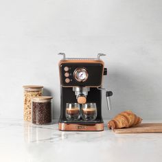 an espresso machine sitting on top of a counter next to croissants