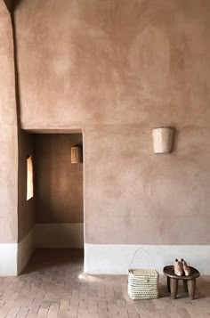 the interior of a house that is made out of clay and has a basket on the floor