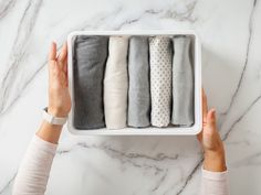 a woman's hands holding an open box with five pairs of socks in it