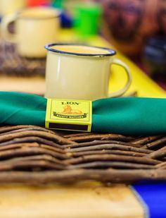 a coffee cup sitting on top of a table next to a green cloth covered napkin