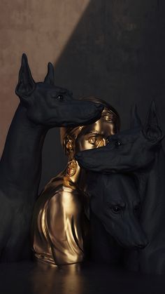 two black rhino statues with one gold statue behind them