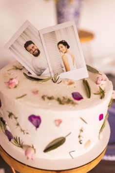 a wedding cake with two photos on top