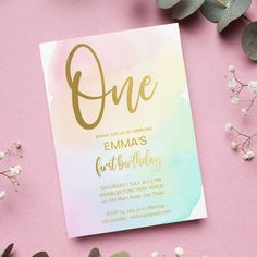 a pink and green birthday card with the word one on it, surrounded by greenery