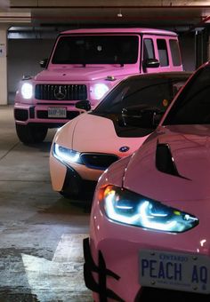 three pink cars parked in a parking garage