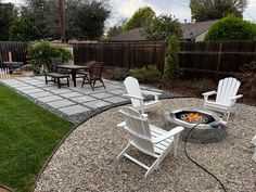 an outdoor fire pit surrounded by lawn chairs and graveled patio area with seating around it