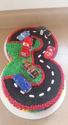 a birthday cake with cars and trucks on the top is made to look like it's number three