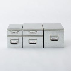 three metal filing boxes sitting side by side on a white surface with the lids closed