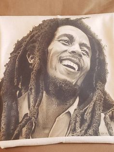 a black and white photo of a smiling man with dreadlocks on his face