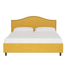 a bed with a yellow headboard and white sheets