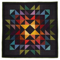 a quilted square with many different colored triangles on it's sides and one in the center