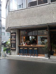 the outside of a restaurant with blue chairs