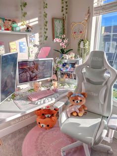 a desk with two teddy bears sitting on it in front of a computer monitor and keyboard