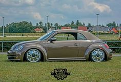 a brown car parked on top of a lush green field