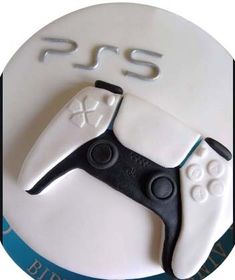 a white cake with a video game controller on it's side and the word ps3 spelled out