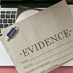 a piece of paper with the word evidence on it next to a computer keyboard and mouse