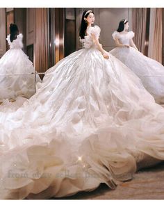 three mannequins dressed in white gowns and dresses with ruffled skirt