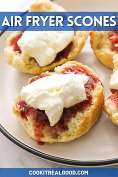 some scones with cream and strawberries are on a plate