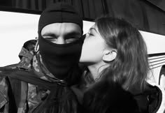 two people in black and white kissing each other while wearing skis on their heads