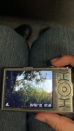 a person holding a cell phone in their lap with the screen showing an image on it