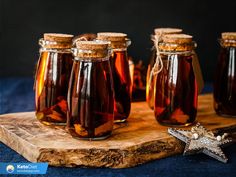 four jars of honey sit on a wooden cutting board next to a star ornament