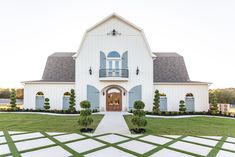 a large white house with blue shutters on the front