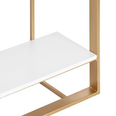 a white table with gold legs and a shelf on the top that has a square shaped object attached to it