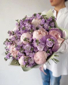 a woman holding a bouquet of flowers in her hands