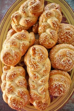 a plate full of bread rolls covered in sesame seeds